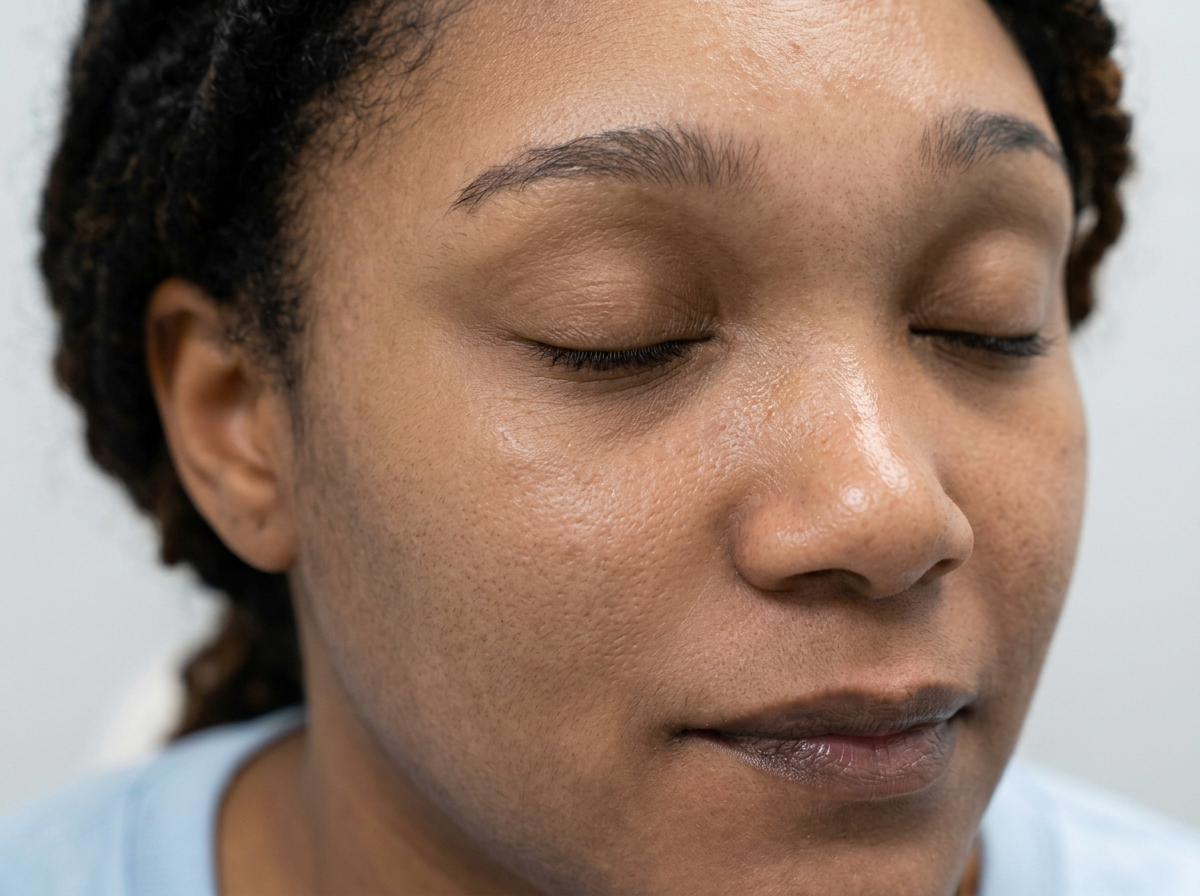 Close-up of a woman with closed eyes against a plain background